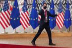 A security guard walks near EU and U.S. flags, before the EU-US summit, in Brussels, Belgium June 15, 2021. REUTERS/Yves Herman