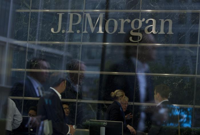 Workers are reflected in the windows of the Canary Wharf offices of JP Morgan in Lo<em></em>ndon September 19, 2013.  REUTERS/Neil Hall