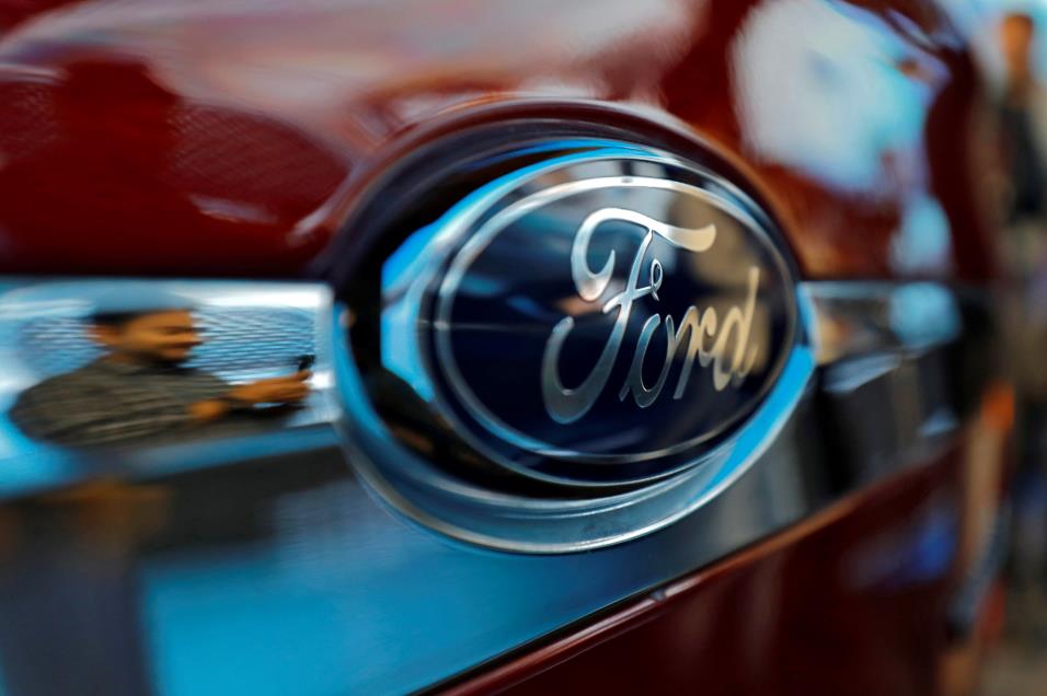 A visitor is reflected as he takes pictures of a Ford Aspire car during its launch in New Delhi, India, Oct. 4, 2018. REUTERS/Anushree Fadnavis/File Photo