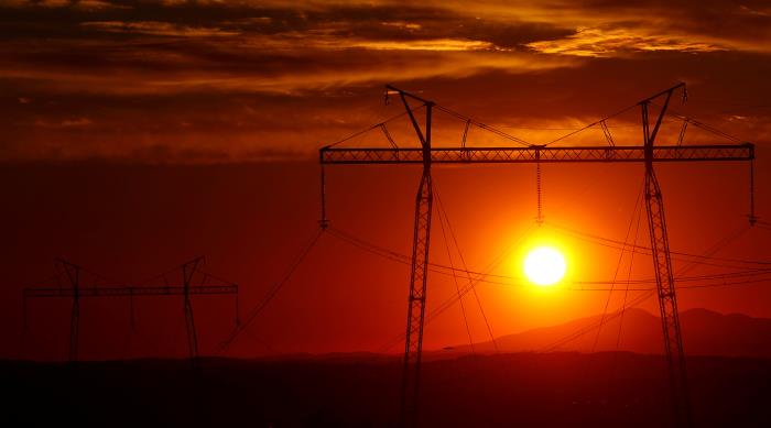 The sun sets behind electric power transmission lines near the town of Sachkhere, some 200 km (124 miles) north-west of Tbilisi, September 13, 2013. REUTERS/David Mdzinarishvili/File Photo