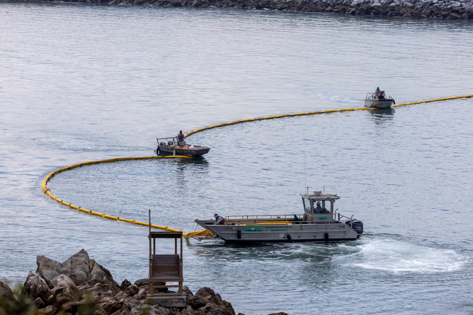 Workers seal off the entrance to Newport Beach harbor as a major oil spill off the coast of California travels south in ocean currents, towards Newport Beach, California, U.S., October 4, 2021. REUTERS/Mike Blake