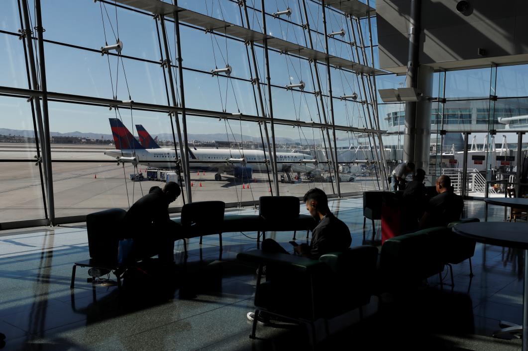 Travelers sit in a lounge area as Delta Air Lines plane park at a gate in McCarran Internatio<em></em>nal Airport in Las Vegas, Nevada, U.S., February 14, 2020. Picture taken February 14, 2020.  REUTERS/Shannon Stapleton