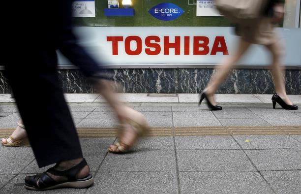 Pedestrians walk past a logo of Toshiba Corp outside an electro<em></em>nics retailer in Tokyo September 14, 2015. REUTERS/Toru Hanai/File Photo