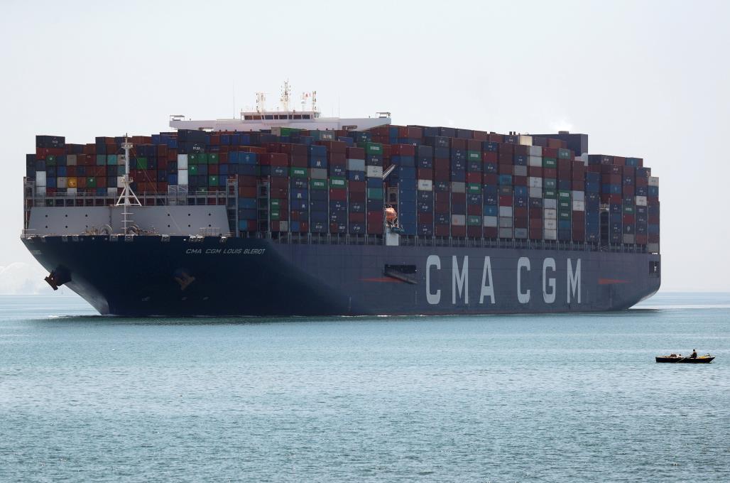 A fisherman travels on a boat in front of a CMA CGM co<em></em>ntainer ship passing through the Suez Canal in Ismailia, Egypt July 7, 2021. REUTERS/Amr Abdallah Dalsh