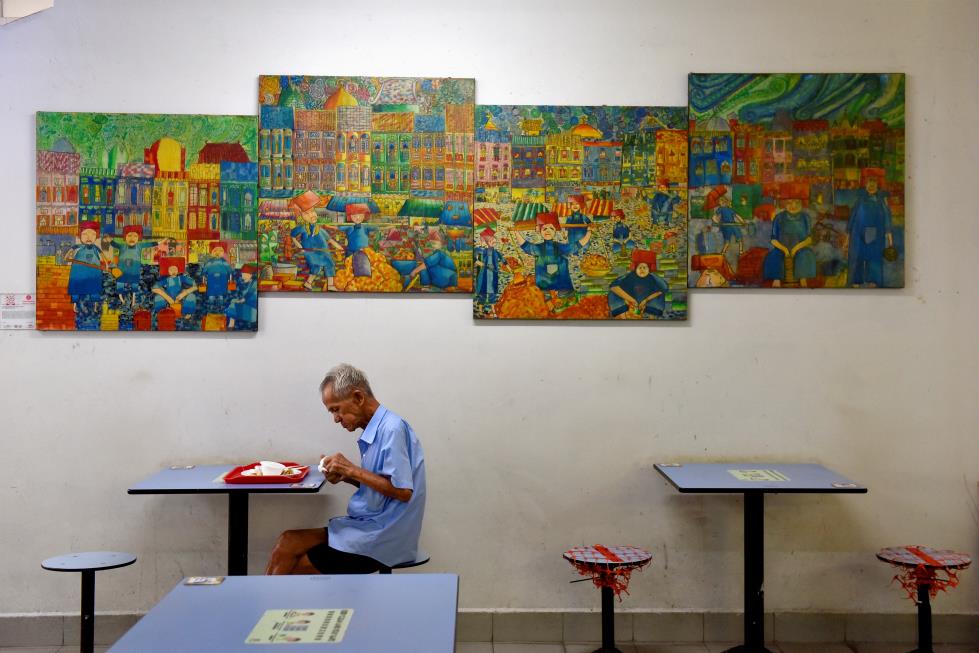 A man dines alone in a food centre, amidst dining regulations imposed by the government which o<em></em>nly allow up to two people to dine together, amidst the coro<em></em>navirus disease (COVID-19) pandemic, in Singapore November 3, 2021. REUTERS/Caroline Chia/File Photo