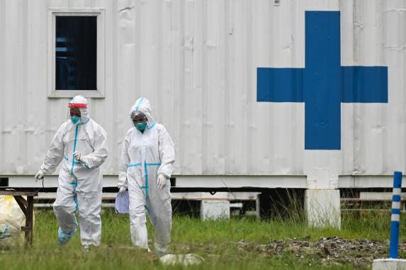 Health workers in hazmat suits walk outside the Manila COVID-19 Field Hospital in Manila, Philippines, September 7, 2021. REUTERS/Lisa Marie David