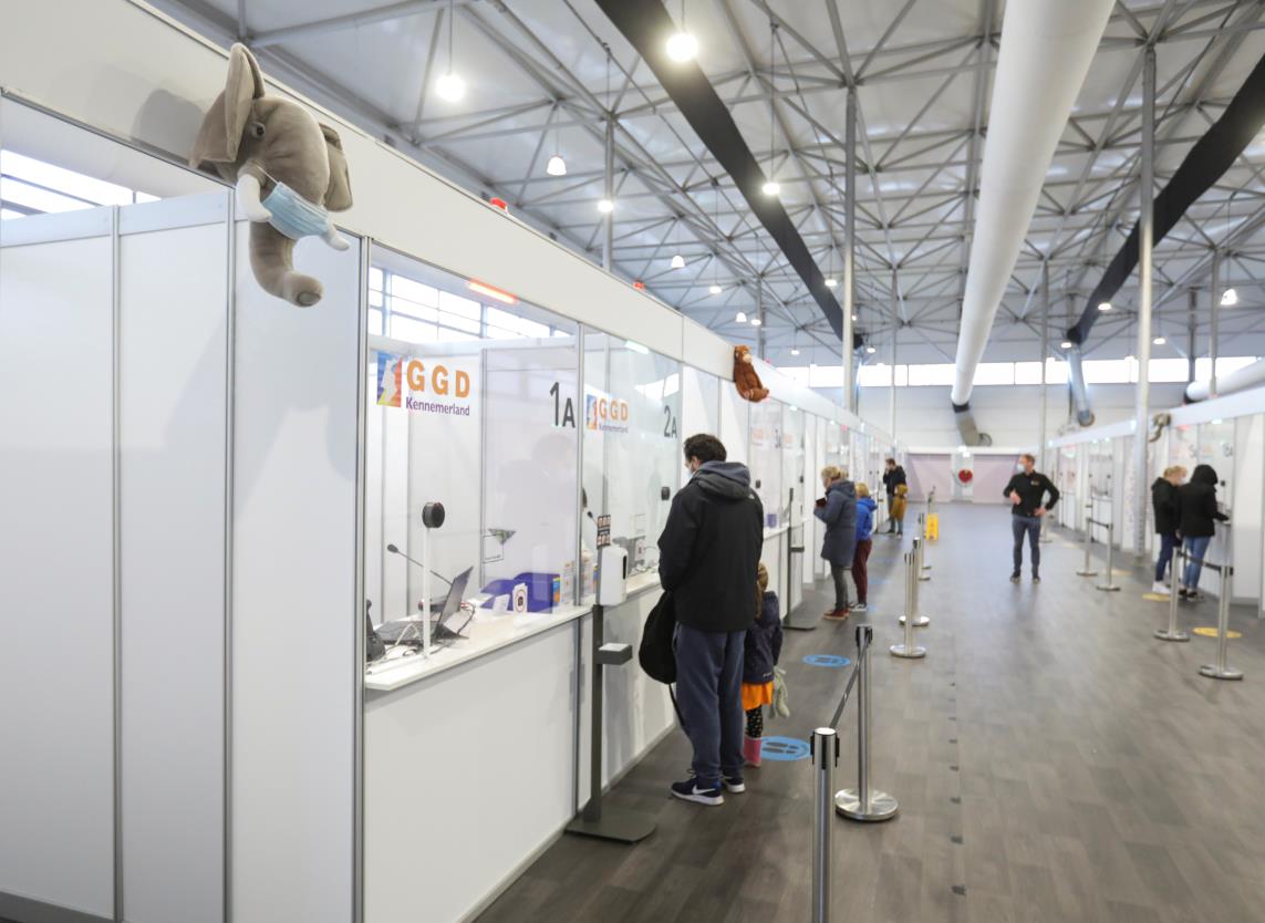 People stand at a counter at the XL Schiphol test location, after Dutch health authorities said that 61 people who arrived in Amsterdam on flights from South Africa tested positive for COVID-19, in Amsterdam, Netherlands, November 27, 2021. REUTERS/Eva Plevier