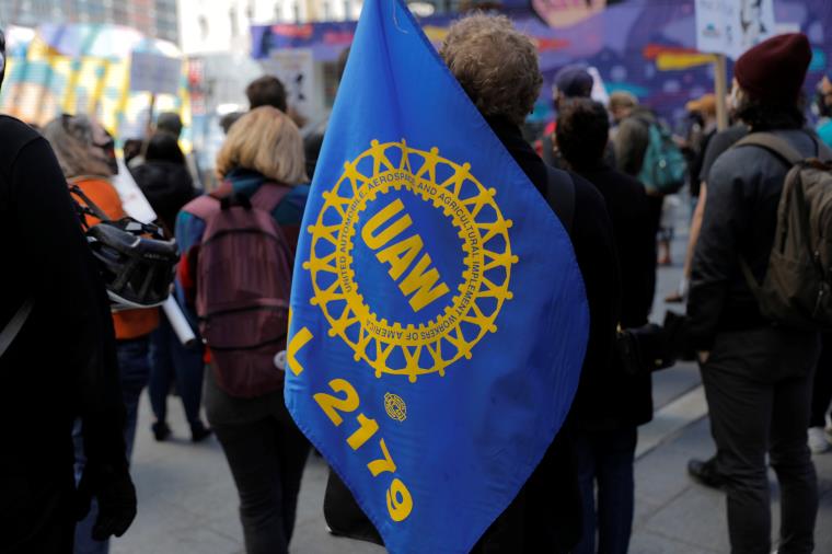 A person carries a flag with the patch from the United Auto Workers (UAW) labor unio<em></em>n during a May Day rally for media workers held by The NewsGuild of New York on Internatio<em></em>nal Workers' Day in Manhattan, New York City, New York, U.S., May 1, 2021. REUTERS/Andrew Kelly