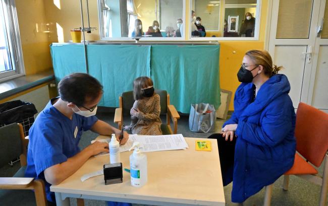 A girl waits at the side of her mother to be inoculated against the coro<em></em>navirus disease (COVID-19) in a Children's vaccination center in Leipzig, Germany, December 10, 2021. REUTERS/Matthias Rietschel