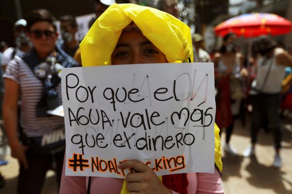 A woman holds a sign that reads: 