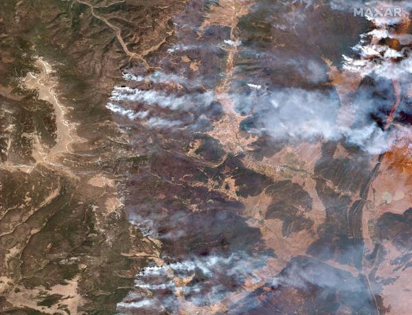 A satellite image shows a natural color overview of the Hermits Peak and Calf Canyon fires, near Las Vegas, in New Mexico