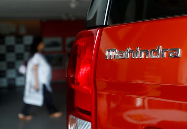 An employee walks past a Mahindra TUV300 car at a showroom in Mumbai