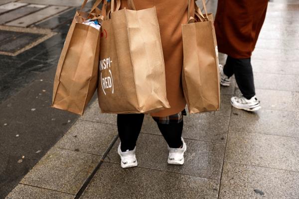 A shopper holds several bags after coming out of a clothing store in central Madrid