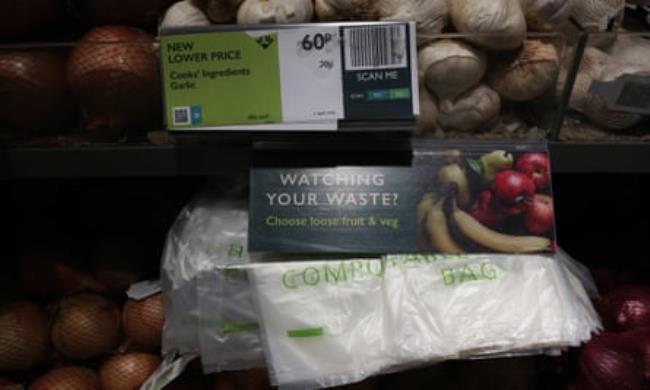 A Waitrose fresh produce section with a sign that reads ‘Watching your waste? Choose loose fruit and veg’