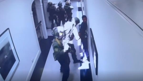 Christian 'King' Combs being arrested in a Homeland Security raid on his father's estate, surrounded by law enforcement in a hallway