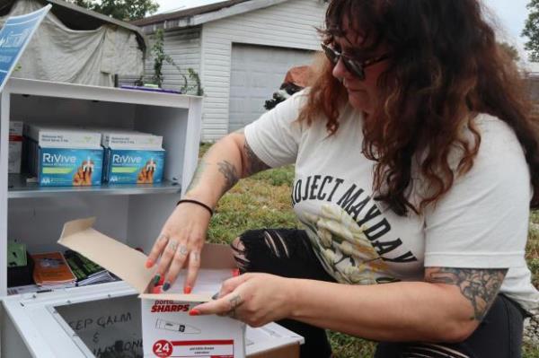 Tasha Withrow, a person in recovery and co-founder of harm reduction organization Project Mayday, refills a new naloxone distribution box in a residential neighborhood of Hurricane, W.Va. on Tuesday, Sept. 24, 2024. (AP Photo/Leah Willingham)