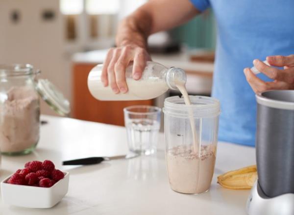 man preparing a protein shake co<em></em>ncept of how to get rid of body flab