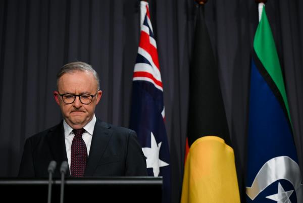 A man in a suit frowns at a lectern