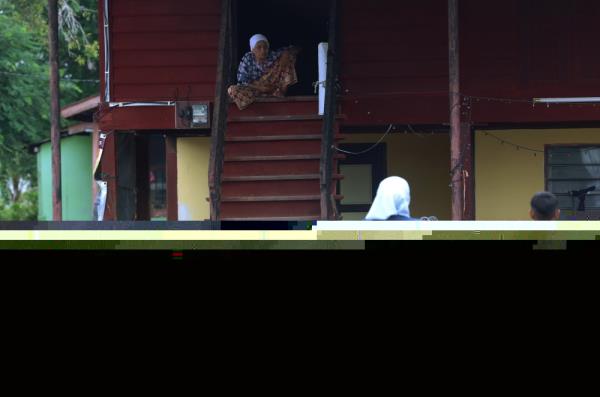 A file photograph shows an aid worker approaching a senior citizen who refused to evacuate during the floods at Kampung Alor Melintang, near Sungai Baru in Alor Setar, Kedah on September 22, 2024. — Bernama pic