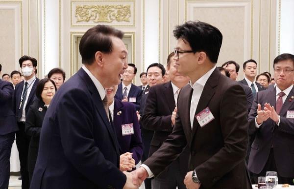 President Yoon Suk Yeol, left, shakes hands with then-ruling People Power Party interim leader and current Chair Han Dong-hoon at a New Year's event held at Cheong Wa Dae in Seoul in January. (Yonhap)