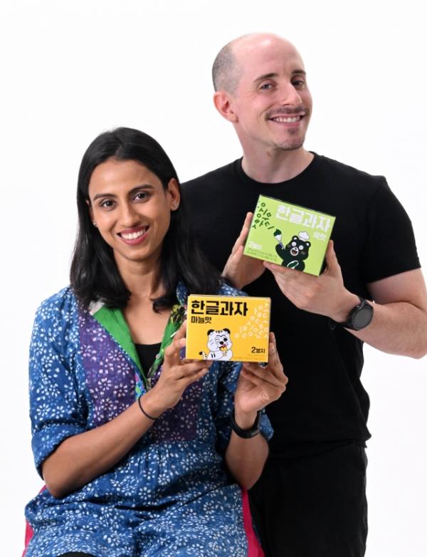 Tyler Rasch (right) and Nidhi Agrawal pose with Hangeul Kwaja, Korean alphabet-shaped docu<em></em>ments, prior to an interview with The Korea Herald Sept. 25 in Seoul. (Im Se-jun/The Korea Herald)