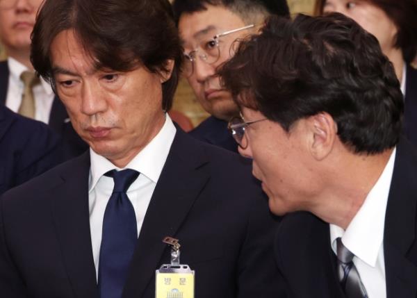 Men's natio<em></em>nal soccer team coach Hong Myung-bo (left) speaks with former Korea Football Association Technical Director Lee Lim-saeng at the parliamentary committee on culture, sports and tourism at the Natio<em></em>nal Assembly in Seoul on Sept. 24. (Yonhap)