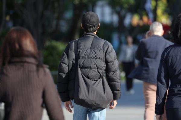 A pedestrian dressed in a padded jacket walk in Jongno-gu, central Seoul, as Seoul saw morning temperatures reach as low as 11.7 C as of 8 a.m., Wednesday. (Yonhap)