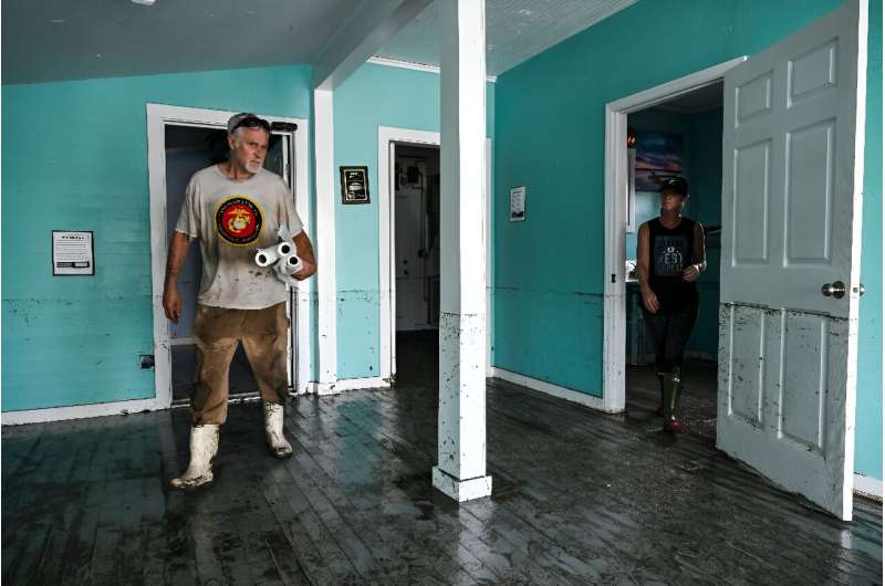 Owner of a wellness center Tamy Wilks (R) cleans her Cedar Key, Florida property with the help of a relative after Hurricane Helene