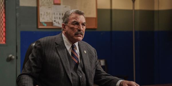 Tom Selleck as Commissio<em></em>ner Frank Reagan sitting behind a desk on Blue Bloods