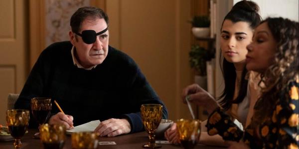 Vince Fish (Richard Kind) wearing an eyepatch and holding a pencil while sitting at a table with Inez (Daphne Rubin-Vega) and her daughter Ana (Lilian Rebelo) in o<em></em>nly Murders in the Building season 4, episode 2, 