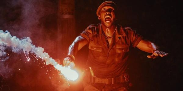 Mahershala Ali looking scared with a flare in Jurassic World Rebirth