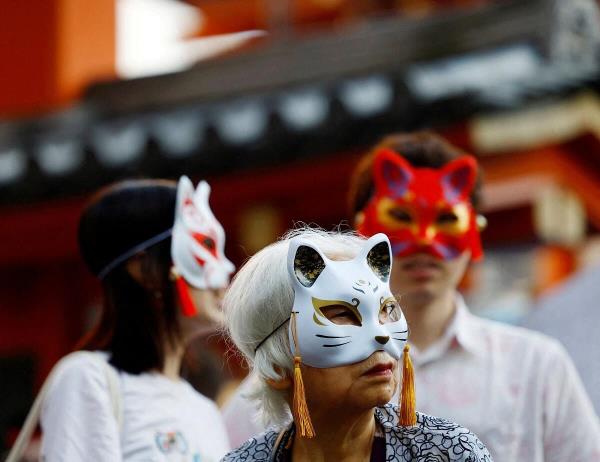 People wait for a parade at the Kagurazaka Bakeneko Festival, attended by participants dressed as cats and supernatural cats, known as "bakeneko", to celebrate the upcoming Halloween, in Tokyo, Japan.