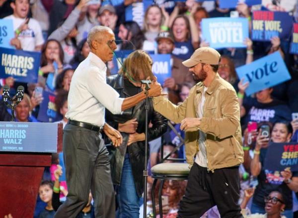 Former President Barack Obama and rapper Eminem embrace during a Kamala Harris campaign rally Tuesday in Detroit.