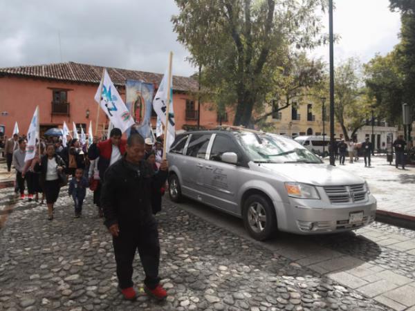 People walk next to a hearse carrying the coffin with the body of priest Marcelo Perez, through the streets in San Cristobal de las Casas, wher<em></em>e he was killed on Sunday after officiating a mass, in San Cristobal de las Casas in the southern state of Chiapas, Mexico, October 20, 2024. REUTERS/Gabriela Sanabria