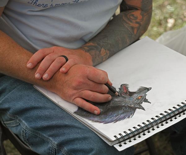 Artist Travis Edmisten, of Essex, works on a sketch at the 61st Havre de Grace Art Show on the waterfront at Tydings Memorial Parks. (Kenneth K. Lam/Staff)