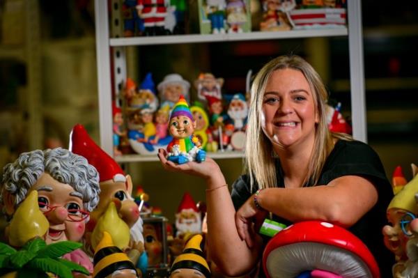 Asda Chief Gnome Handler Katie Chester smiles as she holds a gnome and is surrounded by more gnomes