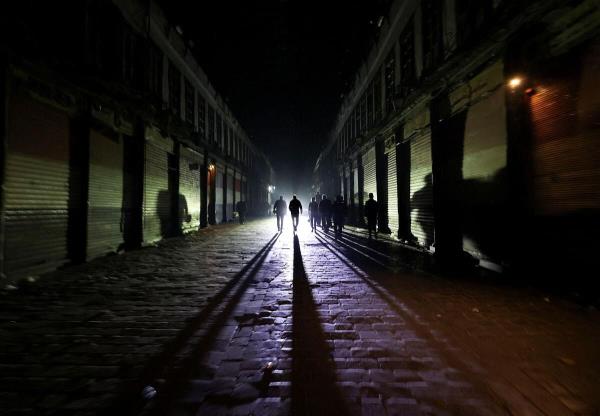 People walk next to closed shops during curfew, after Syrian rebels announced that they have ousted Syria's Bashar al-Assad, in Damascus