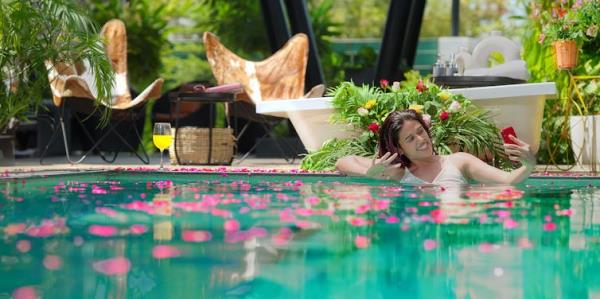 A woman takes a selfie while in a pool.