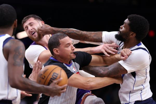 Naji Marshall #13 of the Dallas Mavericks punches Jusuf Nurkic #20 of the Phoenix Suns during the second half at Footprint Center on December 27, 2024 in Phoenix, Arizona. 