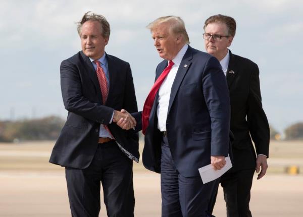 Texas Attorney General Ken Paxton greets then President Do<em></em>nald Trump outside Air Force One in 2019.