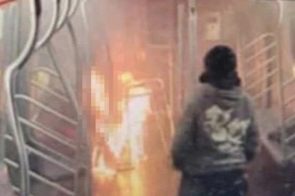 A photo showing phone video footage of the alleged arsonist, watching the woman burn alive last weekend.