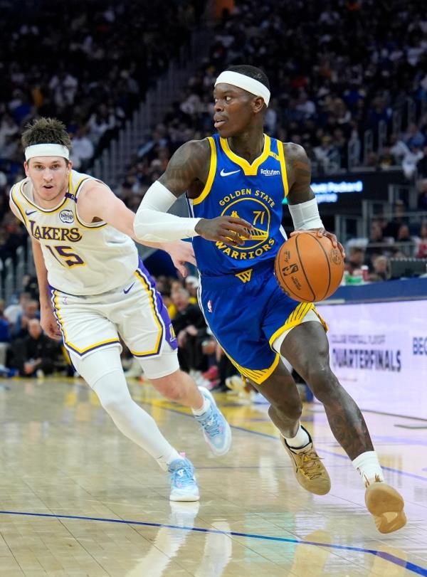 Dennis Schroder (71) of the Golden State Warriors dribbles the ball past Austin Reaves (15) of the Los Angeles Lakers.