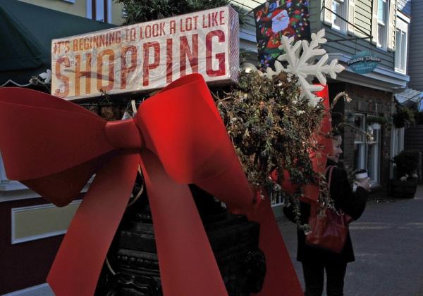 A woman walks past a Christmas bow in a shopping mall in Rehoboth Beach, Delaware