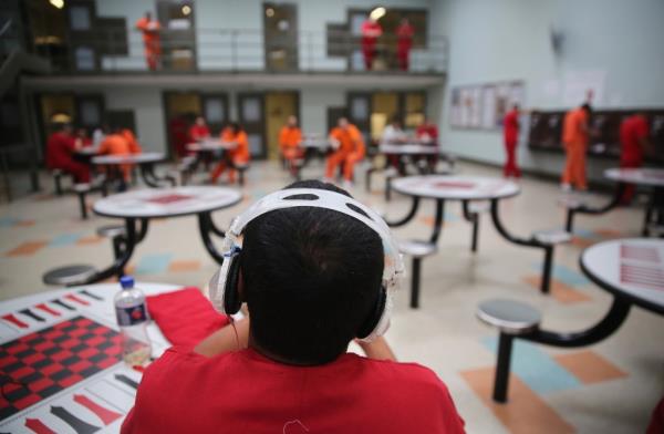 An immigration detainee listens to music in a general population block at Adelanto Detention Facility.