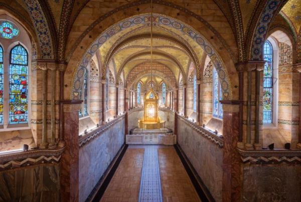 King Charles delivering his annual Christmas Day speech in the gold and marble hallway of Fitzrovia Chapel, London, with a gold and blue ceiling.