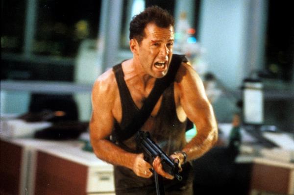 Bruce Willis running with automatic weapon in a scene from the film 'Die Hard', 1988.