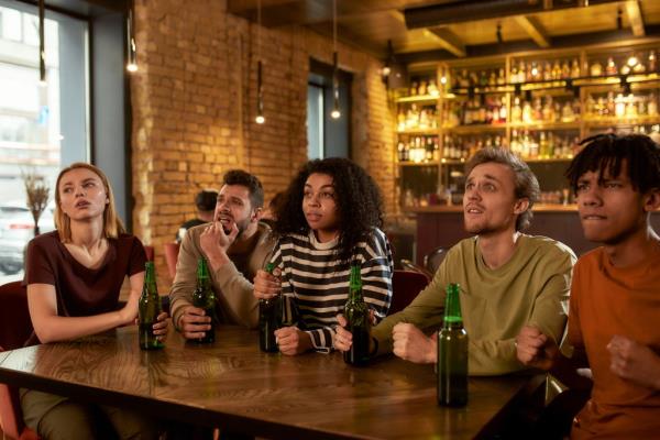 Worried sports fans watching a game over beers at a bar.