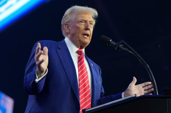 President-elect Do<em></em>nald Trump speaking into a microphone at AmericaFest in Phoenix, 2024