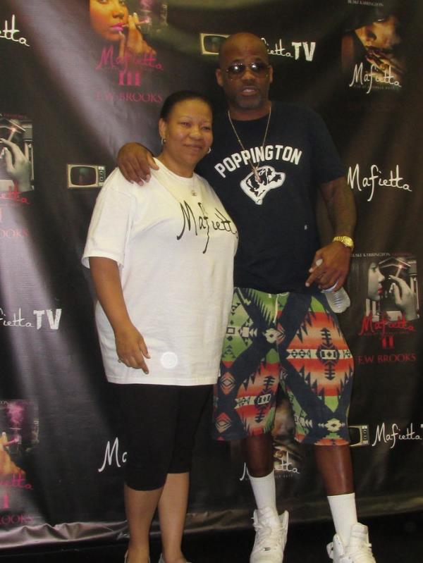 Damon Dash and E.W. Brooks standing in front of a banner