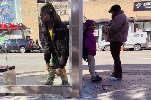 A man leaning against a bus stop shelter at Roberto Clemente Plaza on Nov. 13, 2024.